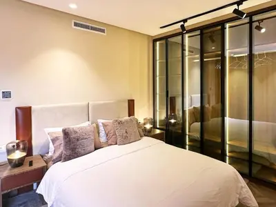 a bedroom with a large white bed with glass walls at Villa du Lac 4 suites in Prestigia in Marrakech
