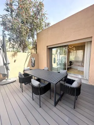 a wooden deck with a table and chairs on it at Villa du Lac 4 suites in Prestigia in Marrakech