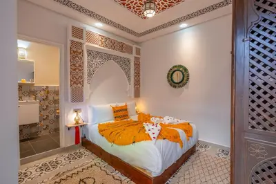 a bedroom with a bed and a bathroom at Riad Dar Al Ghali in Marrakech