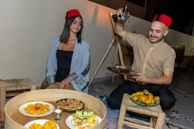 a man and a woman holding up a picture of food at Riad Dar Al Ghali in Marrakech