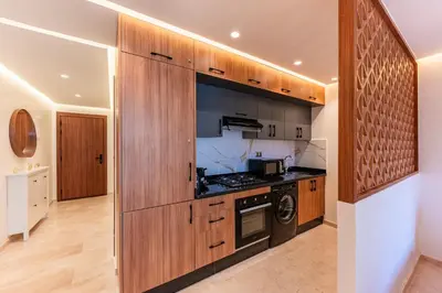 a kitchen with wooden cabinets and a stove at Cocon Balnéo de Gueliz - Central & Balcon in Marrakech