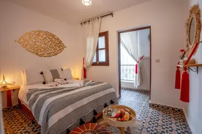 a bedroom with a bed and a large window at Riad Nowara And Spa in Marrakech