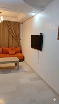 a living room with a couch and a tv on a wall at Au Coeur de L'hivernage P21 in Marrakech