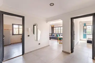 a living room with two sliding doors and a kitchen at Zou Appartement in Marrakech