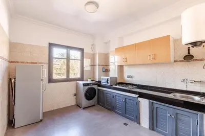 a kitchen with blue cabinets and a white refrigerator at Zou Appartement in Marrakech