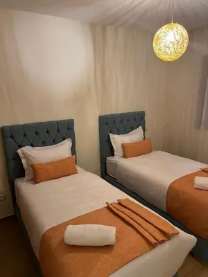 two beds sitting next to each other in a room at Apartment with swimming pool full air-conditioned in Marrakech