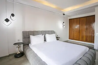 a bedroom with a large bed and a large window at Appart chic et calme avec vue dégagée in Marrakech