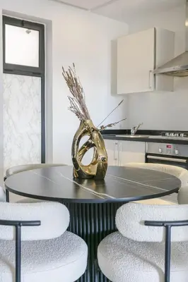 a dining room table with chairs and a vase on it at Appart chic et calme avec vue dégagée in Marrakech