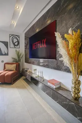 a living room with a television on a wall at Appart chic et calme avec vue dégagée in Marrakech