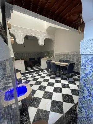 a room with a table and chairs on a checkered floor at Riad Zou Palm in Marrakech