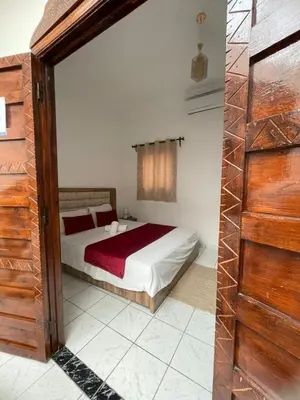 a bedroom with a bed and a wooden door at Riad Zou Palm in Marrakech
