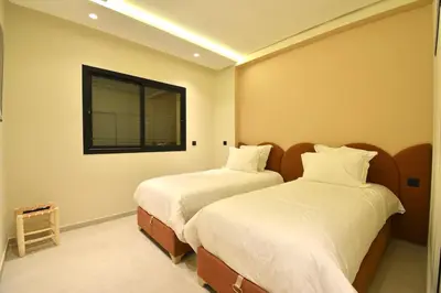 two beds in a room with a window at Le Petit Medina - 4prs - Wifi - Semlalia in Marrakech