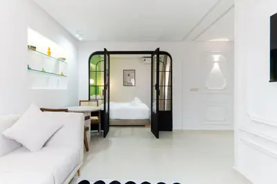 a living room with a white couch and a bedroom at Le Parisien Modern Studio in Hivernage in Marrakech