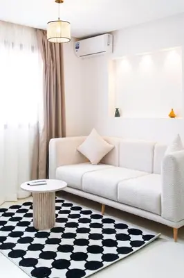 a living room with a white couch and a table at Le Parisien Modern Studio in Hivernage in Marrakech