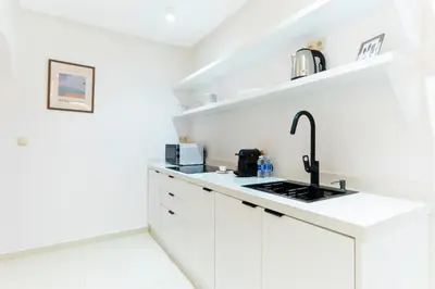 a white kitchen with white cabinets and a sink at Studio Horizon Marrakech Station in Marrakech