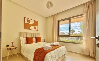 a bedroom with a bed and a large window at Fabuleux T4 110 m2 prestigia Luxury in Marrakech