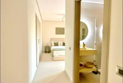 a bedroom with a bed and a sink and a mirror at Fabuleux T4 110 m2 prestigia Luxury in Marrakech