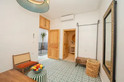 a living room with a mirror and a chair at Riad Timitar in Marrakech