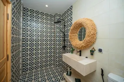 a bathroom with a sink and a shower with a mirror at Riad Timitar in Marrakech