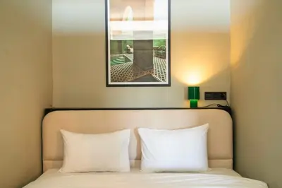 a bed with two white pillows and a picture above it at Majorelle Modern A Unique Green Cocoon in Marrakech