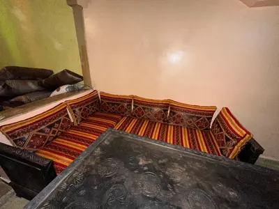 a bedroom with a bed with an orange and brown bedspread at Lina Stay Riad Alkaria Assiyahia in Marrakech