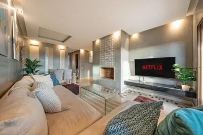a living room with a couch and a tv at Cozy Apt with pool, Wifi, parking, Golf Views & Sunny Private Balcony in Marrakech