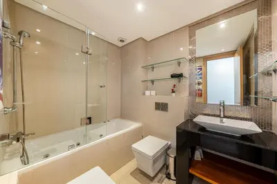 a bathroom with a tub and a toilet and a sink at Cozy Apt with pool, Wifi, parking, Golf Views & Sunny Private Balcony in Marrakech