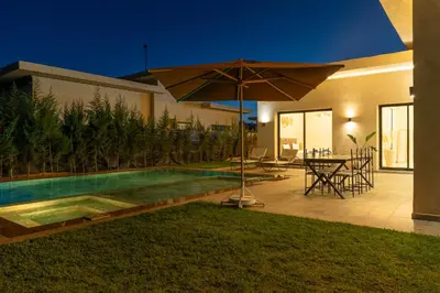 a house with a swimming pool and an umbrella at Domaine des lumières in Segraga