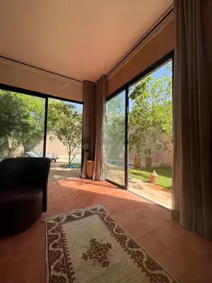 a living room with a large glass door with a couch at Villa privée in Marrakech