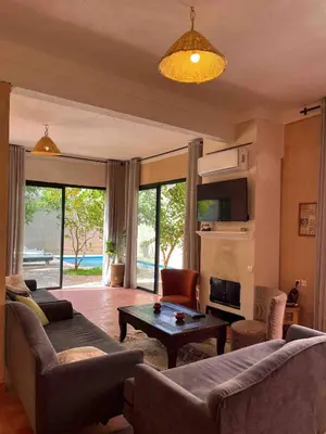 a living room with couches and a table and a couch at Villa privée in Marrakech