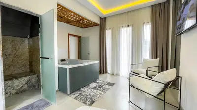 a living room with a chair and a tub at Beautiful Villa Agathe with heated pool in Marrakech