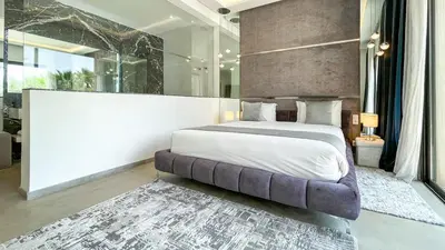a bedroom with a large bed and a large window at Syrine Villa with temperate pool, not overlooked in Marrakech
