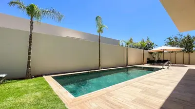 a swimming pool in a backyard with a fence and palm trees at Beautiful Stella villa with heated pool, Marrakech in Marrakech