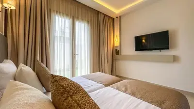 a hotel room with a bed and a television at Beautiful Stella villa with heated pool, Marrakech in Marrakech