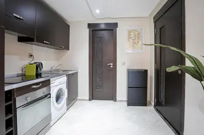 a kitchen with a washing machine and a black door at The Good Mood - Hivernage Marrakech in Marrakech