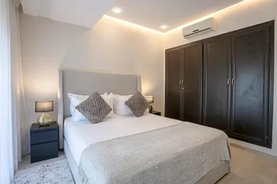 a bedroom with a large bed and a black cabinet at The Good Mood - Hivernage Marrakech in Marrakech