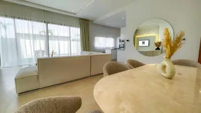 a dining room with a table and chairs and a mirror at Beautiful Bianca villa with heated pool in Marrakech