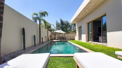 a swimming pool in a yard next to a house at Jade Villa with pool in Marrakesh in Marrakech