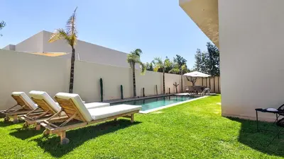 a group of lounge chairs sitting next to a swimming pool at Jade Villa with pool in Marrakesh in Marrakech
