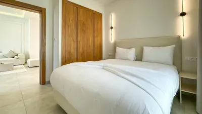 a bedroom with a large white bed and a living room at Villa Eden in Marrakech