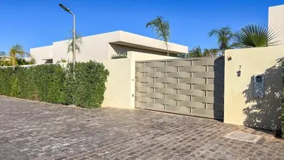 a white house with a fence and a driveway at Villa Eden in Marrakech