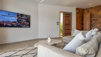 a living room with a couch and a tv on the wall at Beautiful Bahia villa with heated pool in Marrakesh in Marrakech
