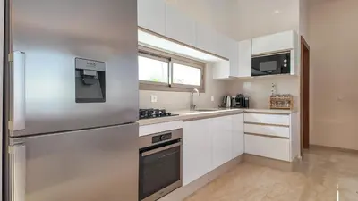 a kitchen with white cabinets and a stainless steel refrigerator at Villa DALIA in Marrakech
