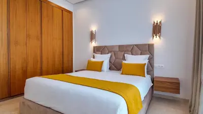 a bedroom with a large white bed with yellow pillows at Villa DALIA in Marrakech