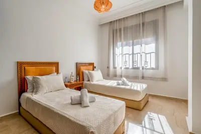 a bedroom with two beds and a window at Relaxing stay with pool & secure parking in Marrakech