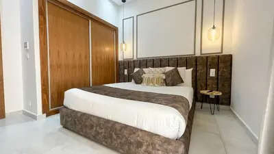 a bedroom with a large bed with a wooden headboard at Villa Balzac Marrakech with heated pool in Marrakech