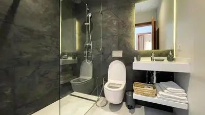 a bathroom with a shower and a toilet and a sink at Villa Balzac Marrakech with heated pool in Marrakech