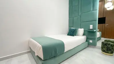 a bedroom with a bed with a green wall at Villa Balzac Marrakech with heated pool in Marrakech