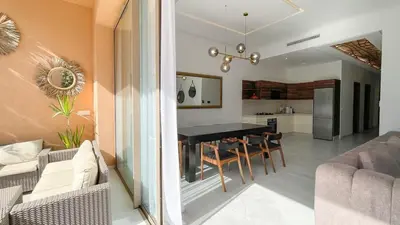 a kitchen and living room with a table and chairs at Villa Balzac Marrakech with heated pool in Marrakech