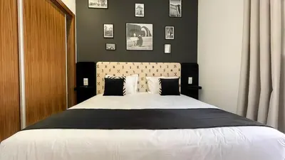 a bedroom with a large bed with black and white pillows at Villa Balzac Marrakech with heated pool in Marrakech